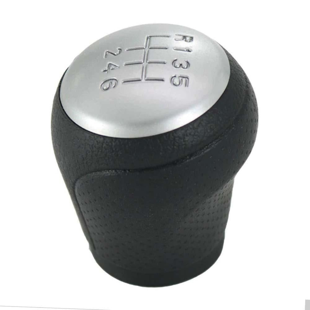 Fekete színű, 6 sebességes Nissan váltógomb. Ezüst színű, 6 fokozatos számlappal.