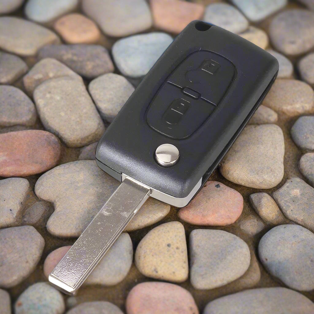 2 gombos, fekete színű Peugeot kulcsház, bicskakulcs nyers kulcsszárral.